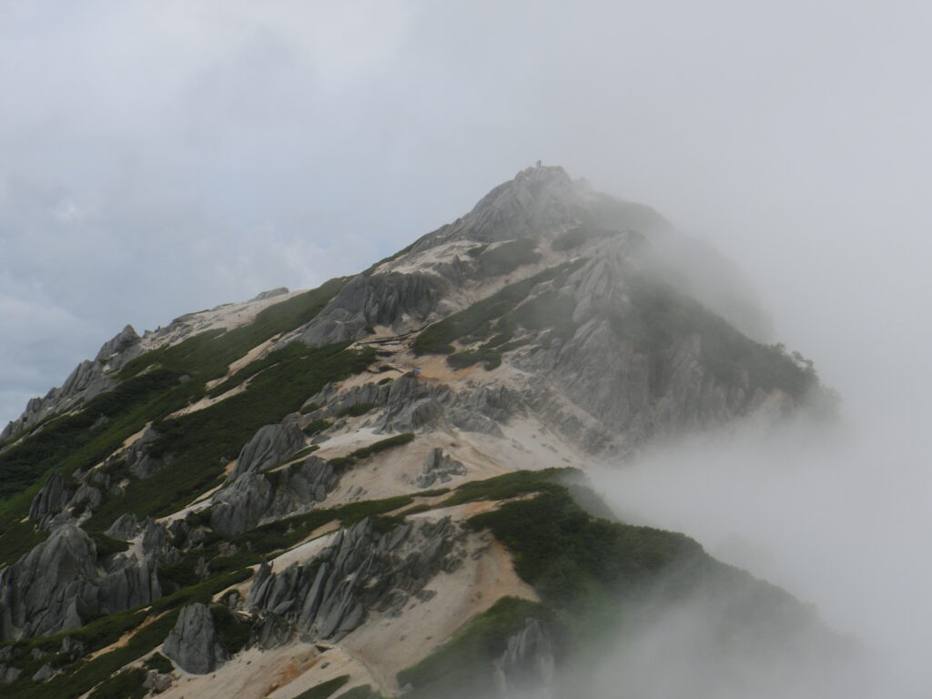燕岳の山頂付近の白い花崗岩の稜線とガス