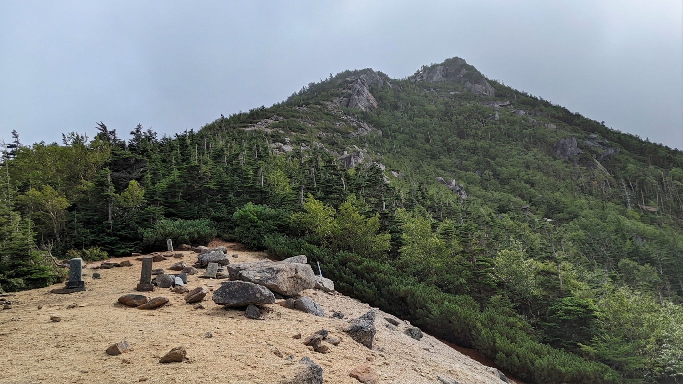白い砂礫の稜線の先にそびえる鋸岳の岩峰