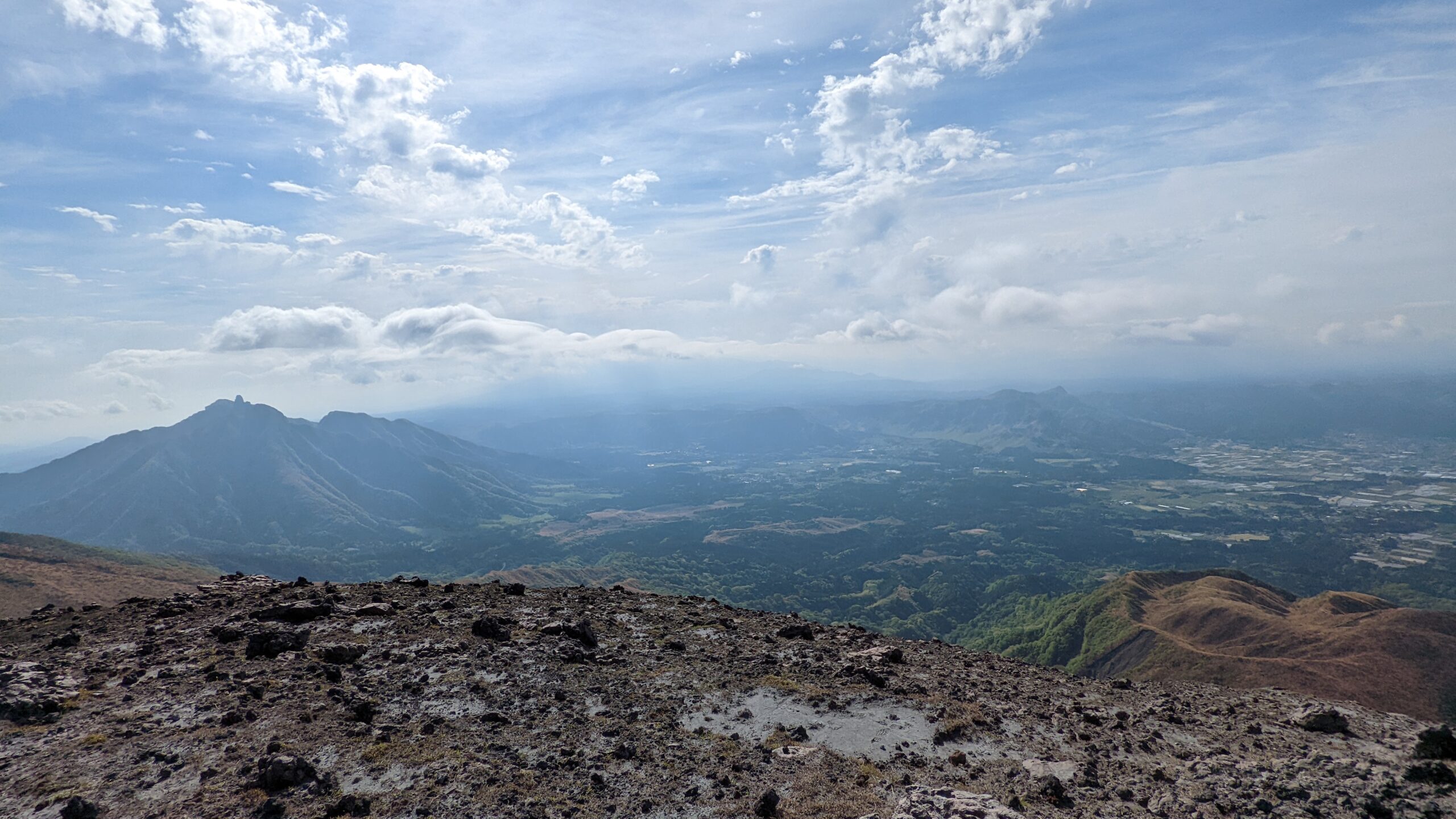 阿蘇高岳の稜線から見下ろしたカルデラ床の田畑と集落、遠くに外輪山