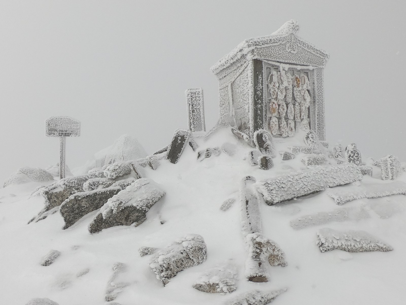 厳冬期の甲斐駒ヶ岳山頂の祠が樹氷に覆われた様子