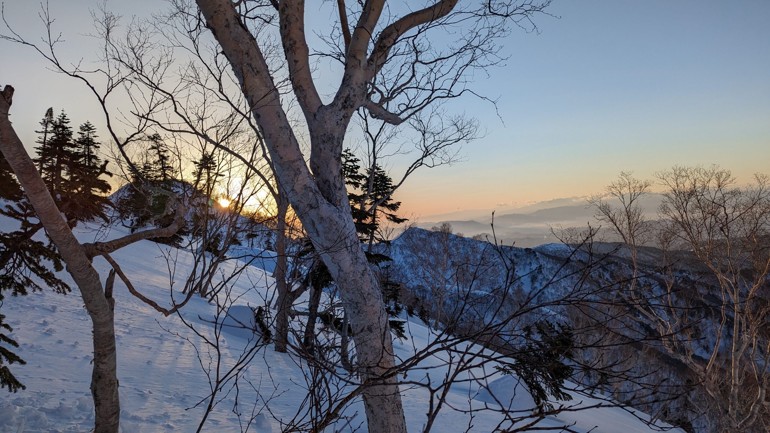 冬の遠見尾根から見下ろす大町側の谷と夕暮れの空
