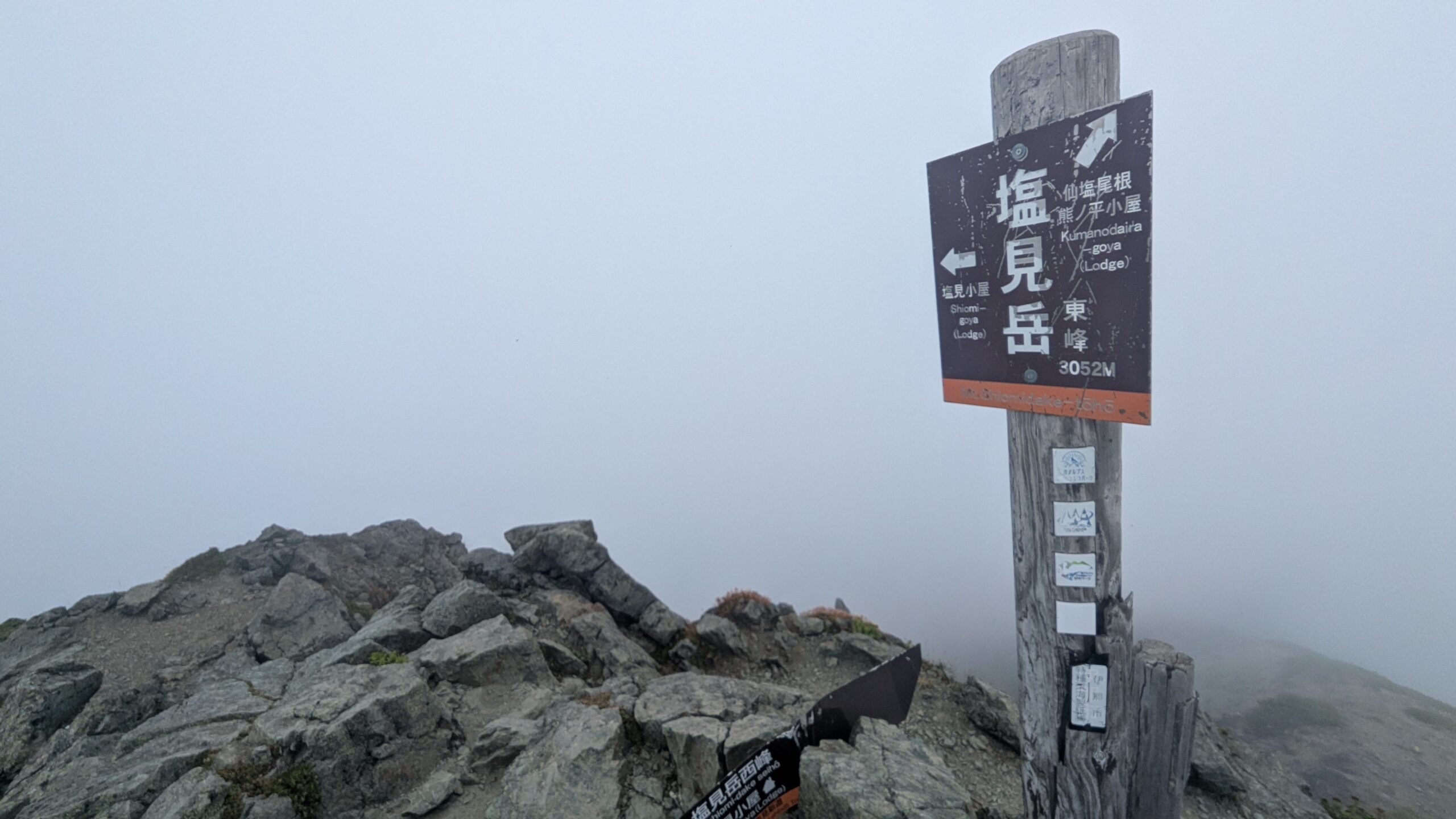 ガスに包まれた塩見岳東峰の山頂標識
